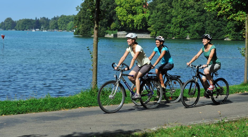 Radfahren am Bodensee mit Blick auf den See und drei Radlerinnen