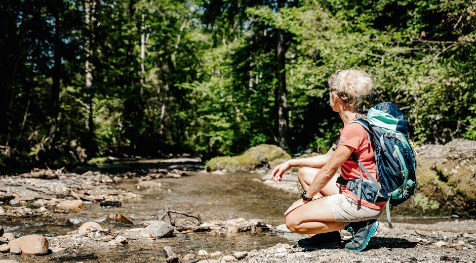 Wandertrilogie Allgäu Wasserläufer, Frau in Hocke vor Wasserfall bei Rettenbach  © Erika Dürr, Allgäu GmbH