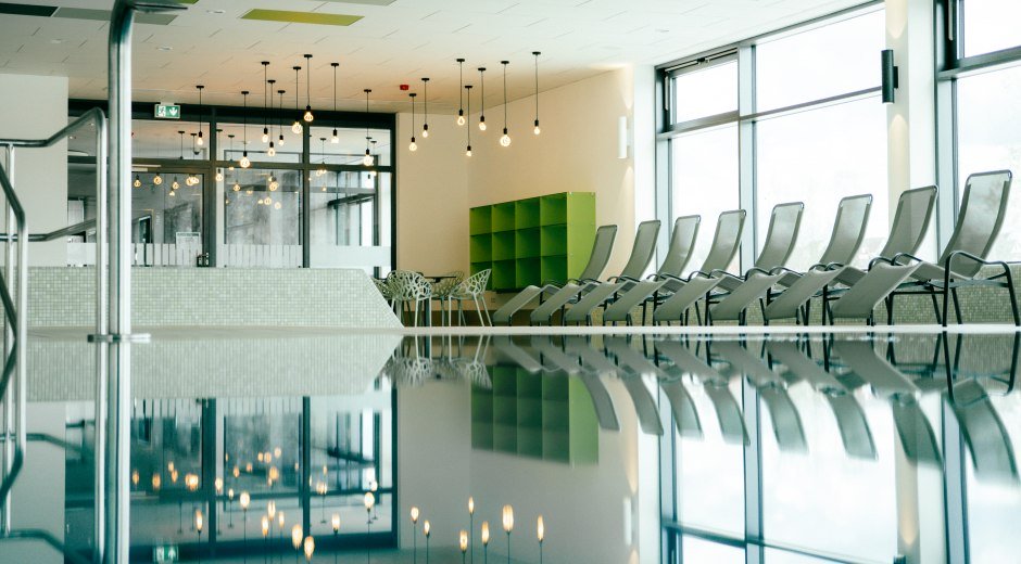 Hallenbad - Becken mit Chlorwasser und Liegestühle am Rand © Ad Partners