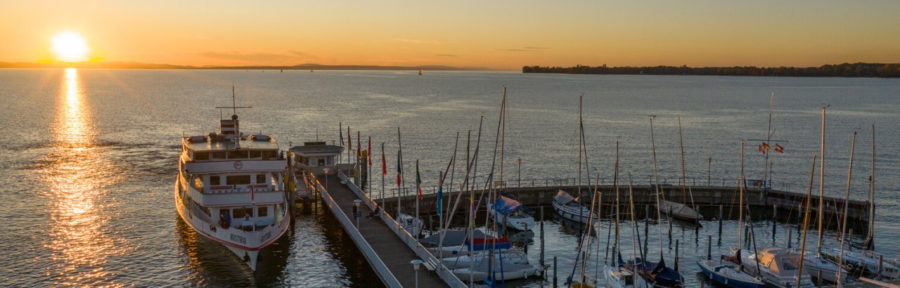 Seglerhafen und Schiff in Nonnenhorn bei Sonnenuntergang &copy; David Knipping
